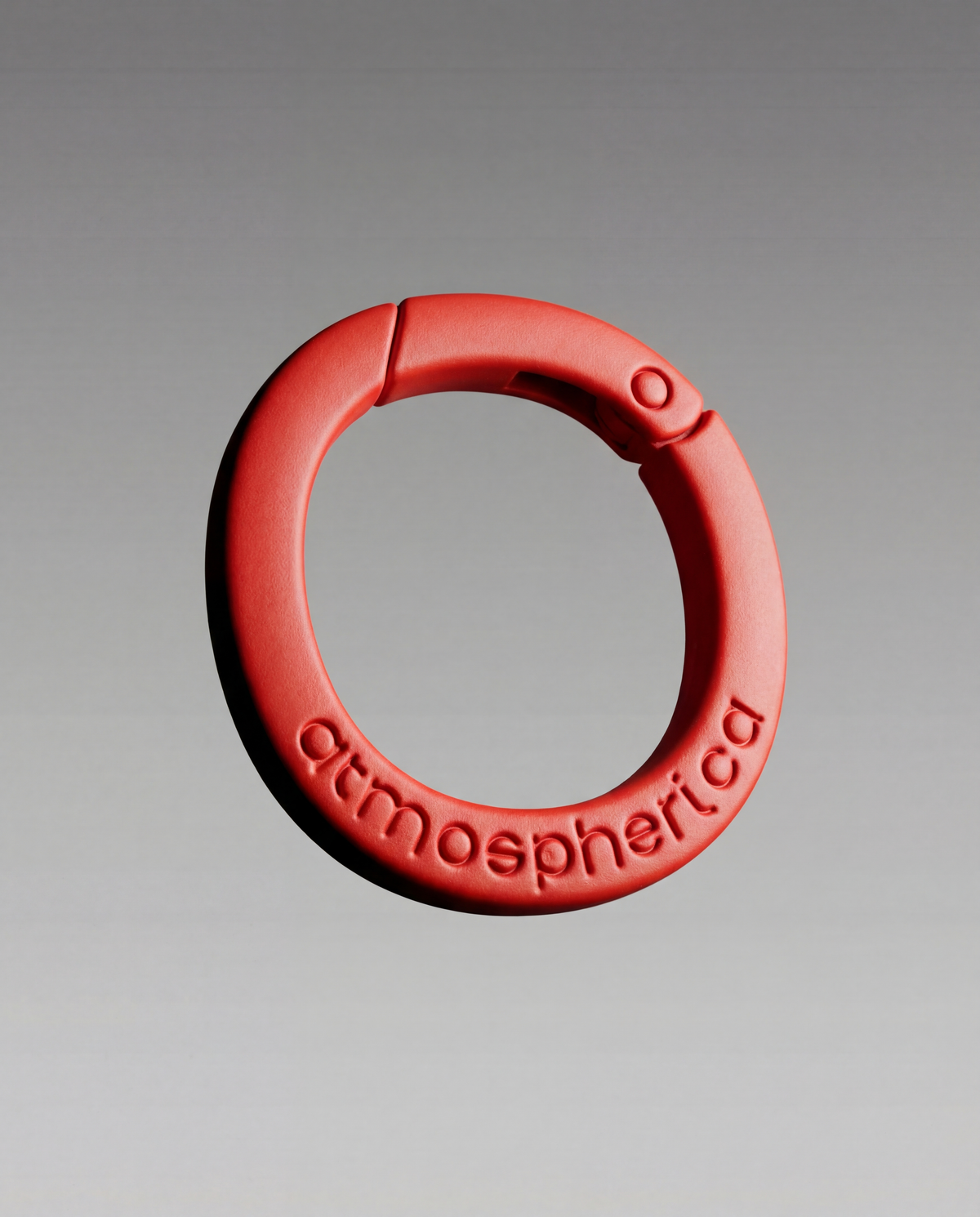 Connecting Loop Magma in primo piano: anello connettore rosso con la scritta atmospherica in rilievo, su fondo grigio